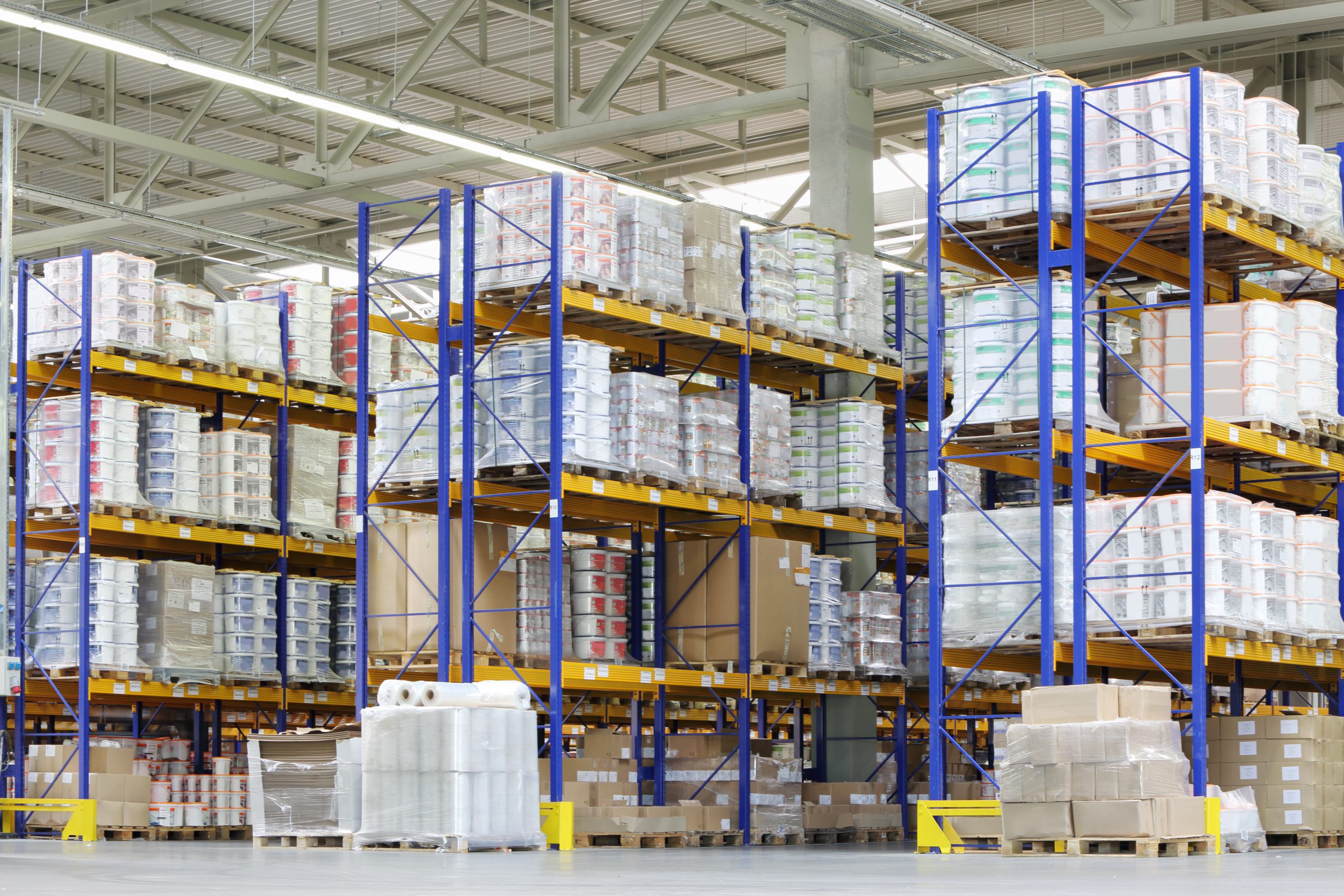 Large warehouse with lots of tall shelves with packed containers.